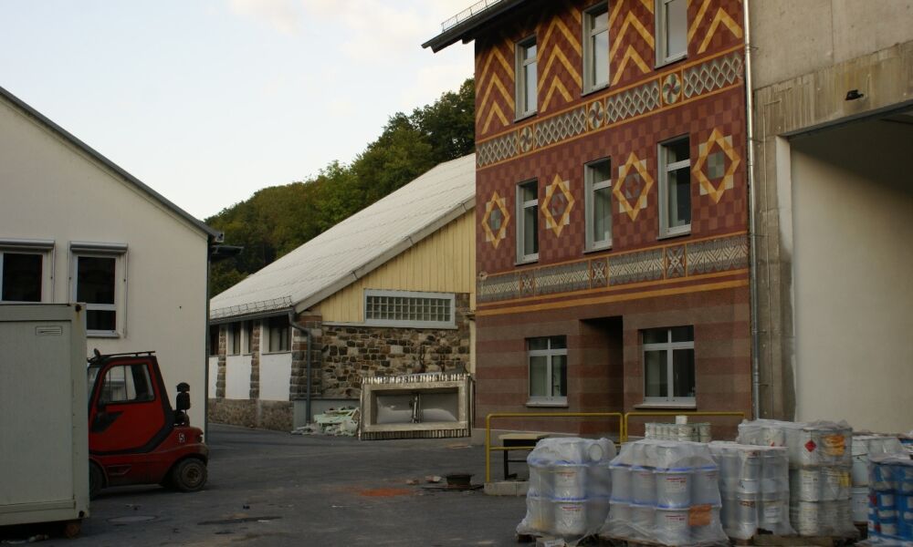 Das Marmoritwerk im Betrieb. Im Hintergrund eine Natursteinwand mit einer instruktiven Sammlung von Gesteinen aus der geologischen Umgebung, die beim Abbruch leider verloren ging. Rechts ein Betriebsgebäude mit Verputz aus der lokalen Produktion, das ebenfalls abgerissen wurde. Dazwischen (rechts im Bild nicht sichtbar) liegt der Eingang zum Stollen.