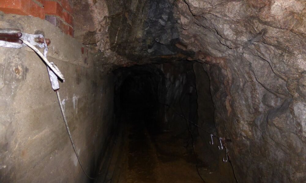 Mittlerer Stollenbereich mit Blick auf das anstehende Gestein: Pegmatit-/Aplitgänge im Granodiorit